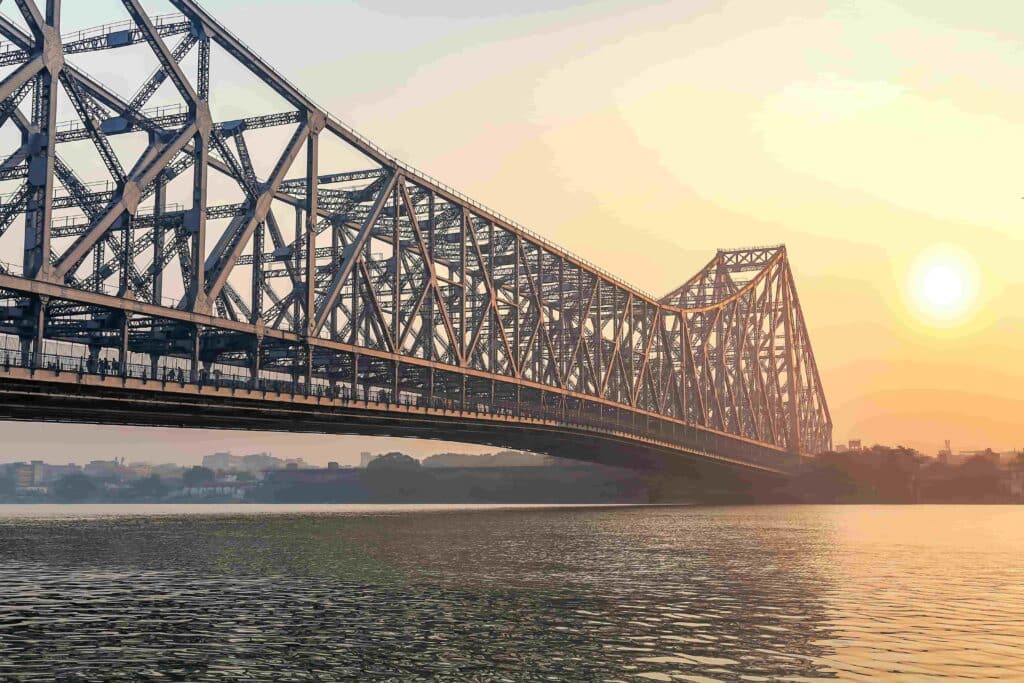Ponte Howrah Calcutá no rio Ganges ao nascer do sol com neblina de inverno. A ponte Howrah é uma das pontes cantilever mais movimentadas da Índia